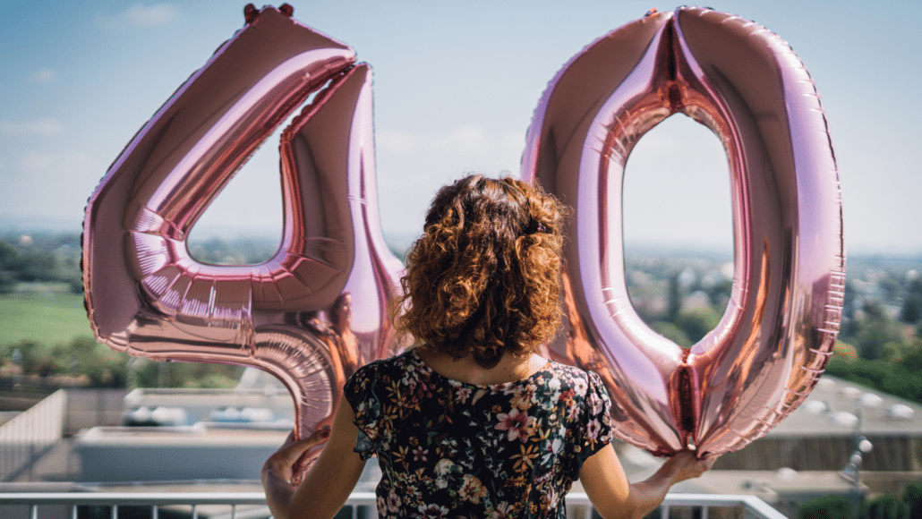 אישה מחזיקה בלונים ליום הולדת גיל 40